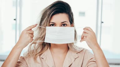 Frau setzt Maske auf