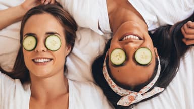 Zwei Frauen mit Gurkenscheiben auf den Augen