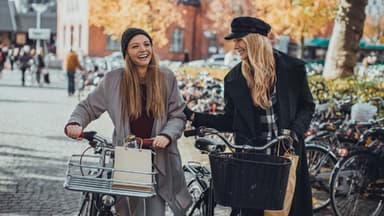 Freundinnen mit Fahrrädern lachen