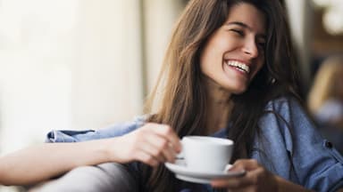 Lächelnde Frau mit Kaffeetasse in der Hand