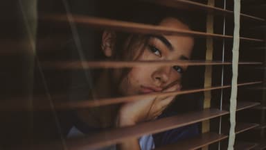 Frau schaut aus Fenster