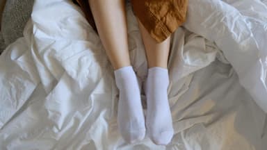 Frau mit Socken im Bett