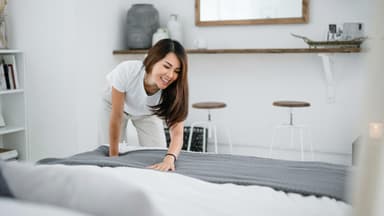 Frau macht das Bett