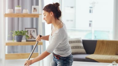 Frau saugt die Wohnung