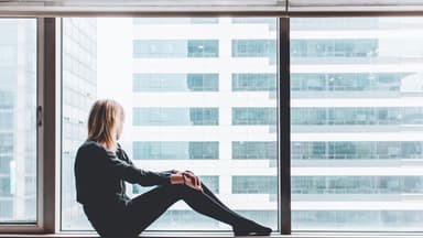 Frau sitzt am Fenster