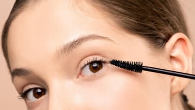 Frau tuscht Wimpern
