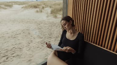Frau liest ein Buch am Strand