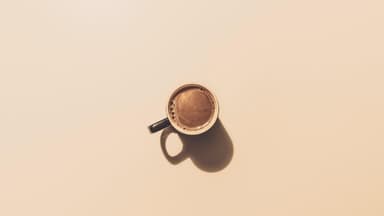 Kaffeetasse auf braunem Hintergrund.