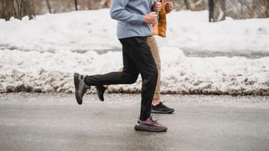 Zwei Personen joggen im Winter.