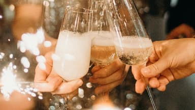 Mehrere Personen stoßen mit Sekt an.