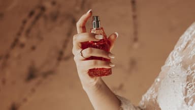 Frau trägt Parfum mit Amber auf.