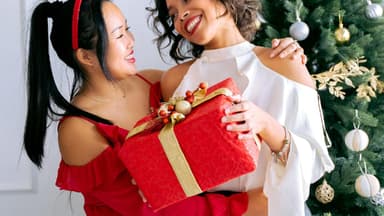 Freundinnen überreichen sich ein Weihnachtsgeschenk