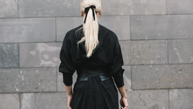 Frau trägt eine schwarze Schleife im Haar.