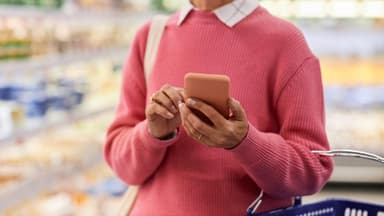 Frau guckt auf Angebote der Supermärkte in der App