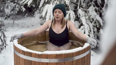 Frau testet, ob Eisbaden gesund ist
