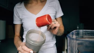 Frau macht sich Proteinshake für mehr Eiweiß