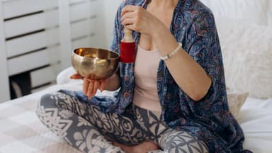 Eine Frau macht ein ayurvedisches Ritual auf dem Bett.