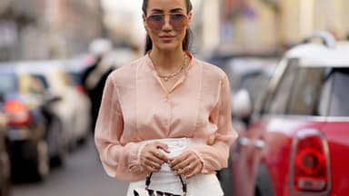 Frau im eleganten Streetstyle mit einer Bluse in der Farbe Peach Fuzz.