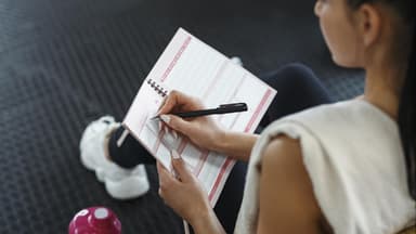 Frau schreibt sich einen Trainingsplan Ganzkörper