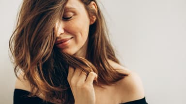 Frau mit Trockenshampoo in den Haaren