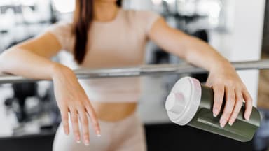 Frau mit Eiweißshake beim Training
