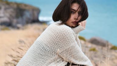 Frau in selbst gestricktem Cardigan