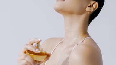 Frau sprüht Pheromon-Parfüm auf ihre Haut
