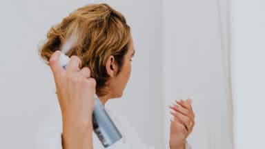 Frau sprüht Haarspray