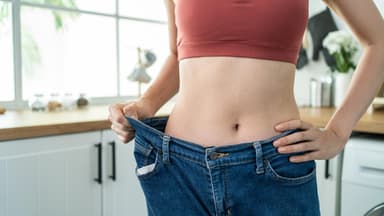 Frau trägt Hose, die zu groß am Bauch ist
