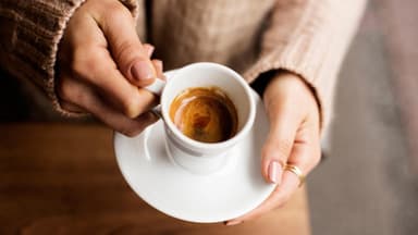 Eine Tasse Espresso in der Hand