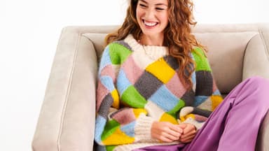 Model in buntem Strickpullover von Lana Grossa