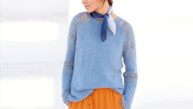 Model in eisblauem Raglanpullover mit Lochmuster