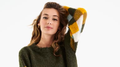 Model in moosgrünem Pullover mit buntem Karomuster von Lana Grossa