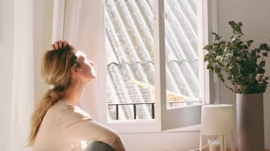 Frau an offenem Fenster
