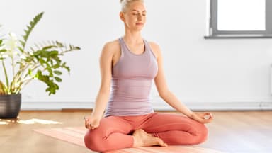Frau macht Yoga für das Immunsystem im Schneidersitz