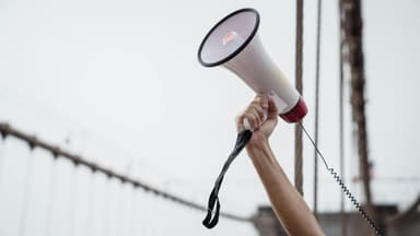 Person hält Megafon in die Luft