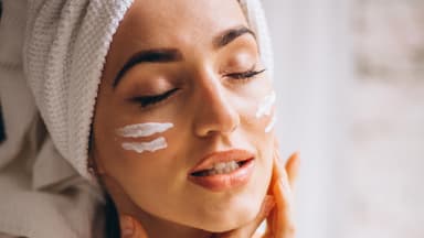 Frau mit Creme im Gesicht