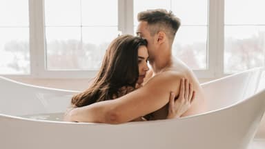 Mann und Frau sitzen umschlungen in der Badewanne