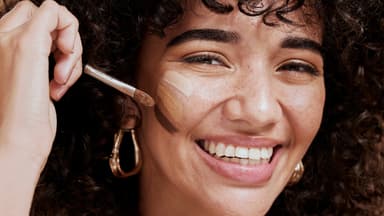 Frau trägt Make-up für trockene Haut von dm auf