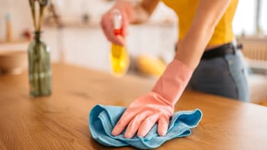 Frau entfernt Staub mit Hausmitteln