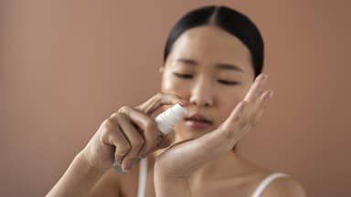 Asiatische Frau verwendet Serum