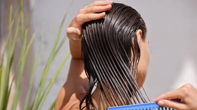 Eine Frau kämmt nasse Haare.