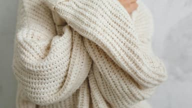 Eine Frau trägt einen selbst gestrickten Pullover aus warmer Wolle