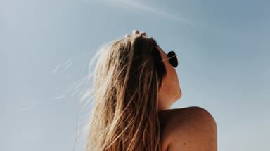 Eine Frau mit Sonnenbrille in der Sonne