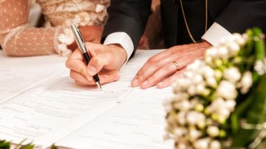 Brautpaar unterschreibt bei standesamtlicher Hochzeit 