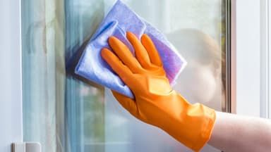 Frau putzt Fenster