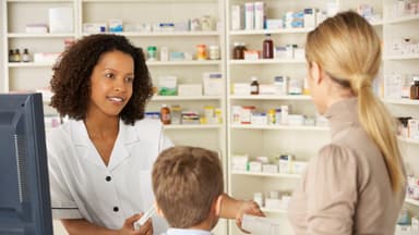 Apothekerin berät Frau mit Kind