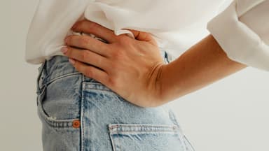 Frau trägt eine zu eng gewordene Jeans