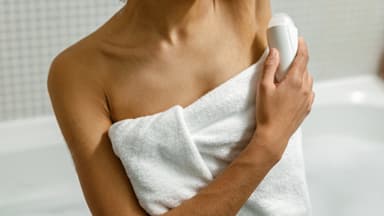 Frau trägt Deo auf
