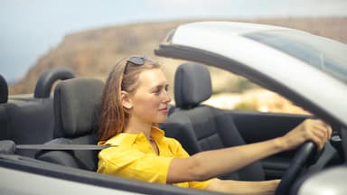 Eine junge Frau sitzt im Auto